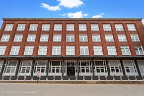 Shreveport apartment for rent - a large brick building with many windows and a street in front