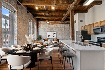 Shreveport apartment for rent - a kitchen and living room in a loft with a table and chairs
