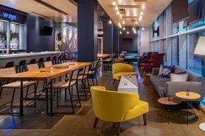 New Orleans apartment for rent - A modern dining area with wooden tables and yellow chairs.