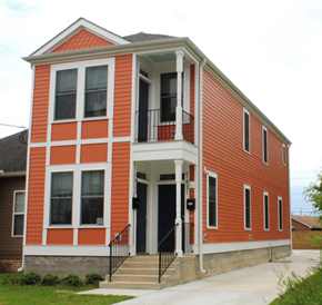 New Orleans apartment for rent - A red and white two story house with a balcony on the second floor.
