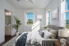 Lake Charles apartment for rent - A bedroom with a bed, a ceiling fan, and a potted plant.