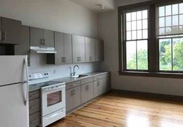 New Orleans apartment for rent - A kitchen with wooden floors and white appliances.