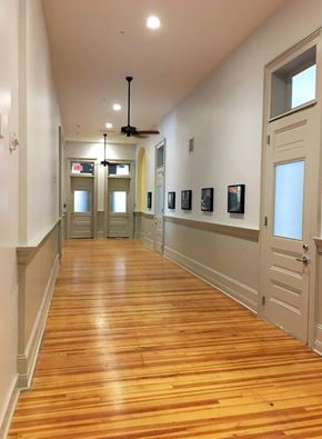 New Orleans apartment for rent - A long hallway with wood floors and white walls.