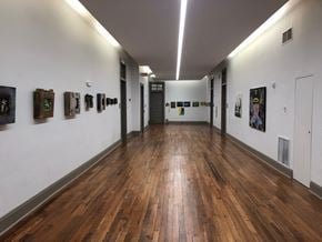 New Orleans apartment for rent - A hallway with wood floors and pictures on the wall.
