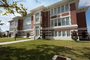 New Orleans apartment for rent - A red and white building with a green lawn in front.