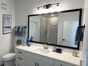 Garden City apartment for rent - a bathroom with a large mirror and a sink and a toilet