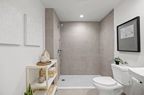 Los Angeles apartment for rent - a bathroom with tiled walls and floor and a walk in shower with a glass door at The Fairfax Flats Apartments, Los Angeles, CA
