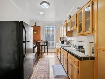Los Angeles apartment for rent - A kitchen with wooden cabinets and a black fridge.