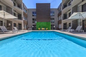 Los Angeles apartment for rent - A swimming pool in front of a building with a green wall at Lafayette Apartments, Los Angeles, CA, 90019