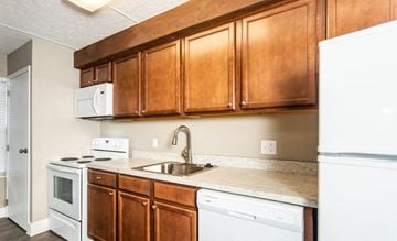 Hilliard townhouse for rent - A kitchen with brown cabinets and white appliances.