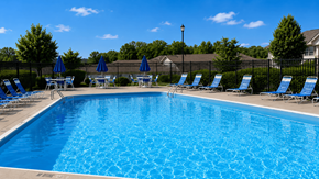 Zanesville apartment for rent - A large blue swimming pool with sun loungers and umbrellas.
