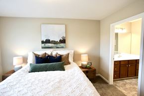 Reynoldsburg apartment for rent - A bedroom with a large bed and a painting on the wall.
