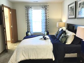 Huber Heights apartment for rent - A bedroom with two beds and a nightstand with a lamp.