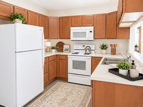 Springfield apartment for rent - A white refrigerator stands in a kitchen with brown cabinets and a white stove.