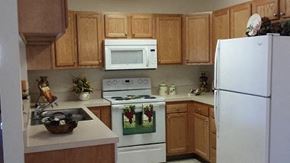 Newark apartment for rent - A kitchen with a white refrigerator, white oven, white microwave, and white sink.