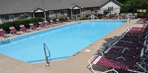 Groveport apartment for rent - A swimming pool surrounded by red chairs.