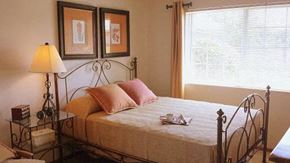Groveport apartment for rent - A bedroom with a bed, a lamp, and two pictures on the wall.