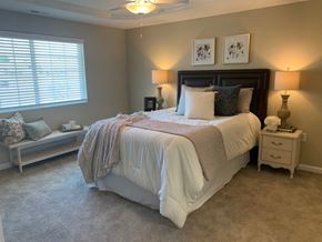 Groveport apartment for rent - A bedroom with a large bed and a window with blinds.