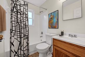 Washington apartment for rent - A bathroom with a toilet, sink, and shower curtain.