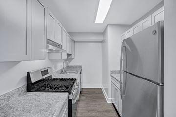 Washington apartment for rent - A modern kitchen with a stove top oven and a refrigerator.