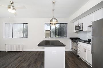 Greenbelt apartment for rent - A modern kitchen with white cabinets and a black island.