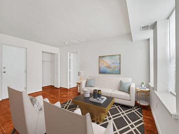 Washington apartment for rent - A living room with a white couch, a coffee table, and a painting on the wall.