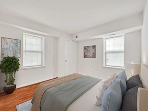 Washington apartment for rent - A bedroom with a bed, pillows, and a potted plant.