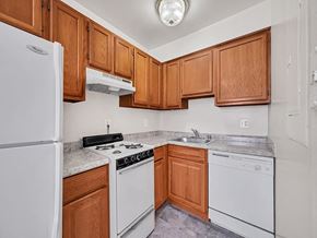 Washington apartment for rent - A kitchen with white appliances and wooden cabinets.