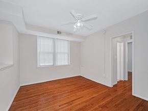 Washington apartment for rent - A room with a ceiling fan and wooden floors.