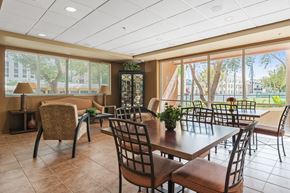 Miami apartment for rent - a dining room with tables and chairs and large windows