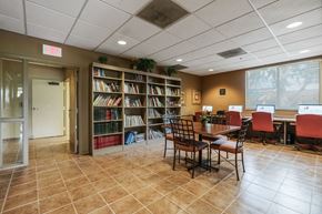 Miami apartment for rent - a library with a table and chairs and a book shelf