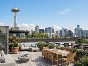 Seattle apartment for rent - Rooftop lounge with outdoor seating and a dining area overlooking the Seattle skyline and Space Needle at 306 QA.