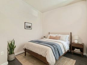 Seattle apartment for rent - Bedroom with a queen bed, nightstand, and warm natural light at 306 QA in Seattle.