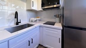 Seattle apartment for rent - a kitchen with white cabinets and a sink and a refrigerator