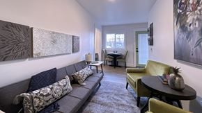 Seattle apartment for rent - a living room with a couch and chairs and a dining room table