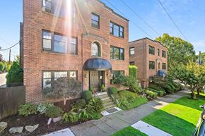 Seattle apartment for rent - the front of a brick apartment building with a sidewalk and grass