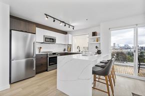 Seattle apartment for rent - a kitchen with white cabinets and a large island with a marble countertop