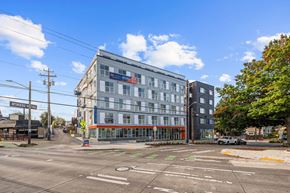 Seattle apartment for rent - A street view with a building on the right and a crosswalk in the foreground.