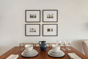 Seattle apartment for rent - a dining table with plates and glasses on it and four pictures on the wall above