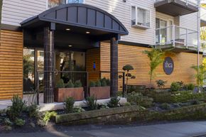 Seattle apartment for rent - A building with a brown wooden exterior and a black awning.