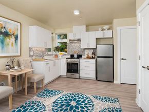 Seattle apartment for rent - a kitchen with white cabinets and a stainless steel refrigerator