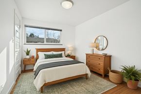 Seattle apartment for rent - A bedroom with a bed, nightstand, and a plant.