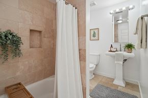 Seattle apartment for rent - A bathroom with a beige tiled shower and a white toilet.