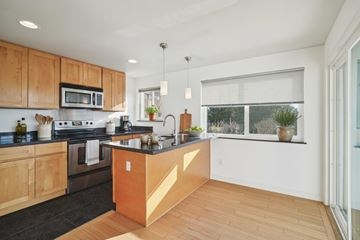 Seattle apartment for rent - A kitchen with wooden cabinets and a black countertop.