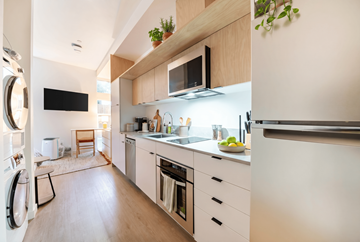 Seattle apartment for rent - A modern kitchen with white cabinets and a wooden countertop.
