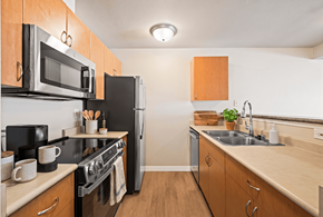 Seattle apartment for rent - A kitchen with wooden cabinets and a black stove top oven.