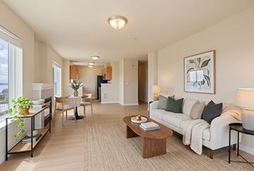 Seattle apartment for rent - A well-lit living room with a white sofa and wooden coffee table.