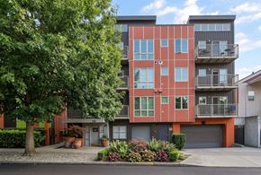 Seattle apartment for rent - Exterior view of REV Fremont featuring terracotta and dark siding, private balconies, and ground-level entrance.