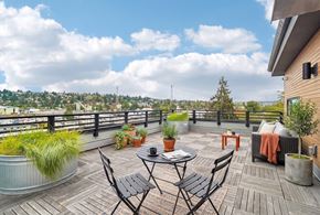 Seattle apartment for rent - Rooftop deck with a bistro table and chairs, lounge seating, and planters overlooking the neighborhood.