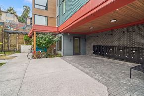 Seattle apartment for rent - Paved building entrance at 609 with resident mailboxes, a bench, and a bicycle parked alongside.